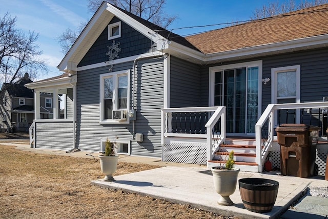 exterior space featuring a patio area and roof with shingles