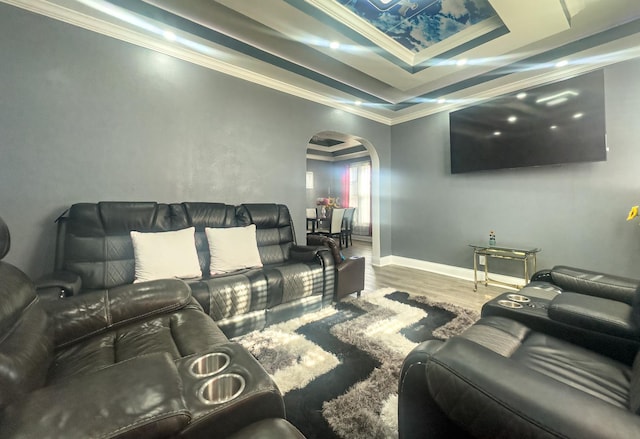 living room with baseboards, arched walkways, ornamental molding, wood finished floors, and a tray ceiling