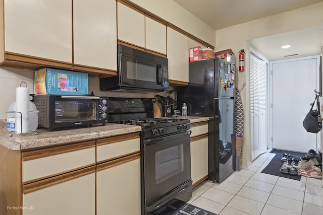 kitchen featuring black appliances, light tile patterned floors, white cabinetry, and light countertops