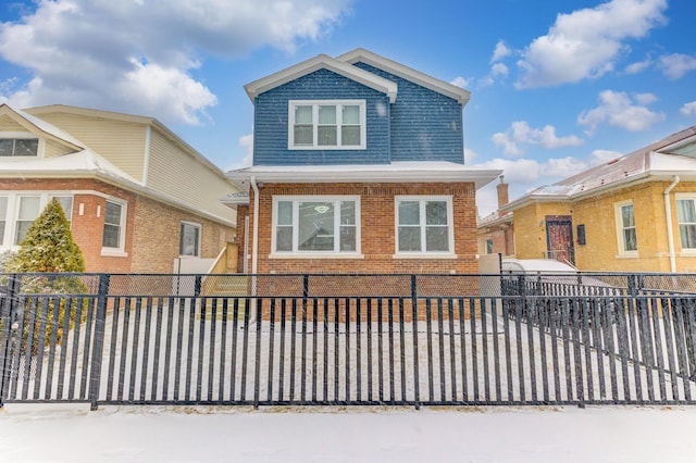 view of front of house featuring brick siding and a fenced front yard