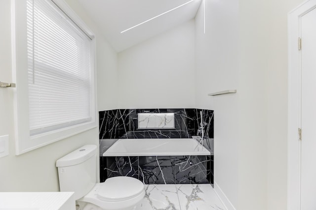 full bath with marble finish floor, a garden tub, vaulted ceiling, and toilet