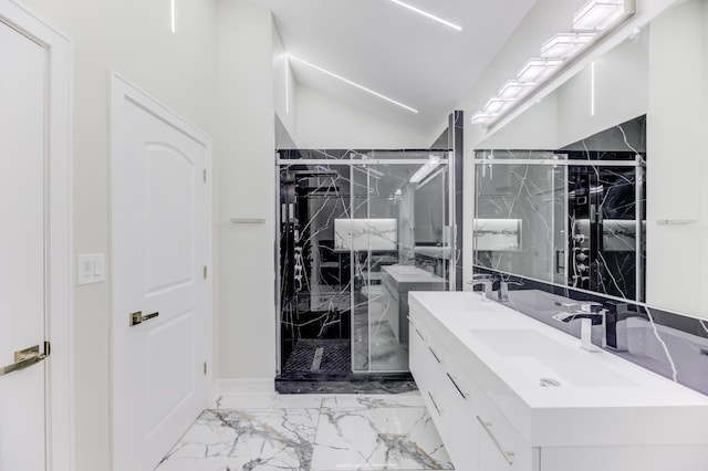 bathroom featuring a sink, vaulted ceiling, marble finish floor, a marble finish shower, and double vanity