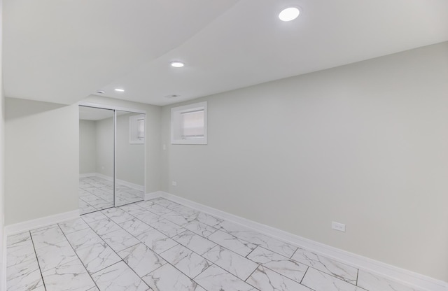 basement with marble finish floor, baseboards, and recessed lighting