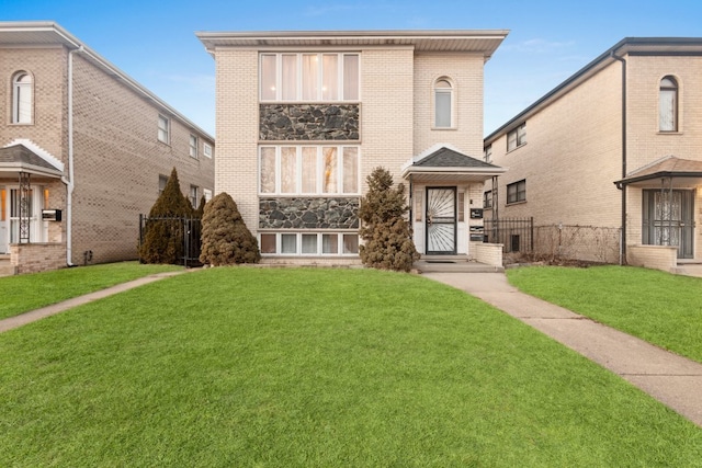 view of front of house featuring a front yard, brick siding, and fence