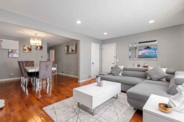 living room featuring wood-type flooring, baseboards, a chandelier, and recessed lighting