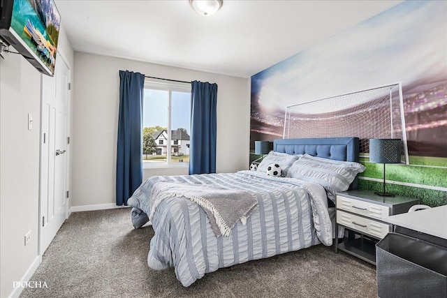 bedroom with dark colored carpet and baseboards