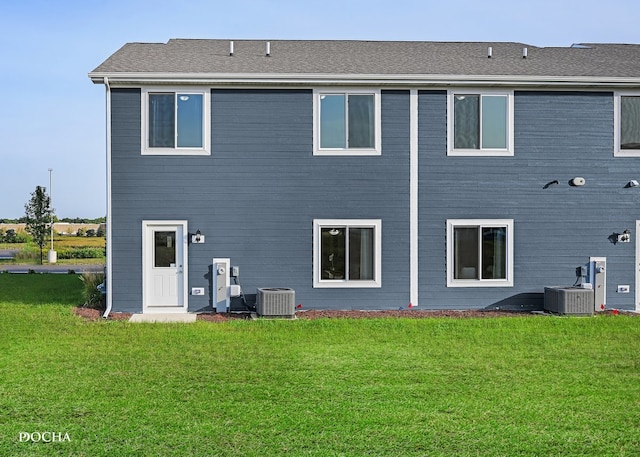 rear view of house with a yard and central air condition unit