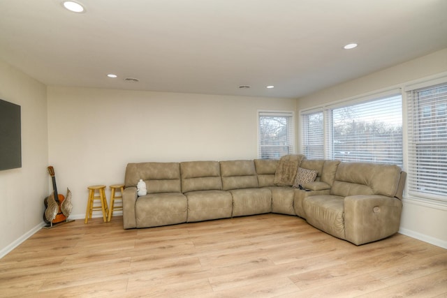 living room featuring light wood-type flooring, baseboards, and recessed lighting