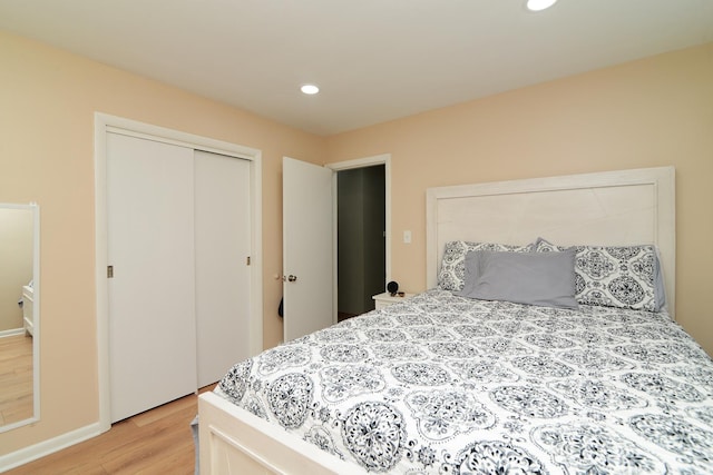 bedroom with recessed lighting, a closet, and wood finished floors