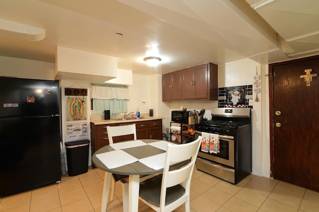 kitchen featuring light countertops, dark brown cabinets, black appliances, a sink, and light tile patterned flooring