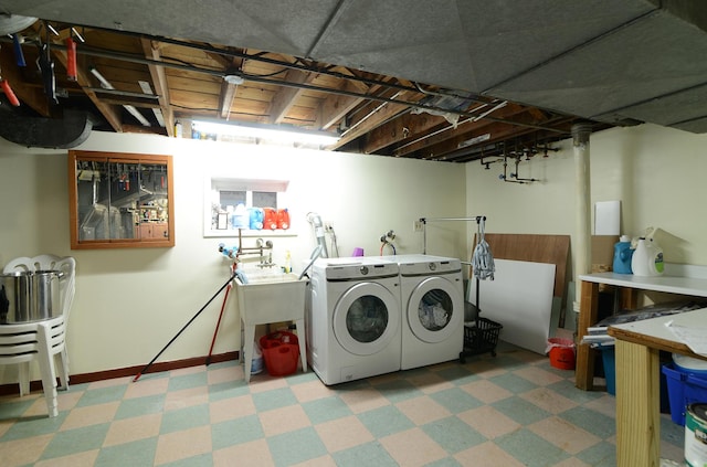 laundry room with light floors, laundry area, baseboards, and washing machine and clothes dryer