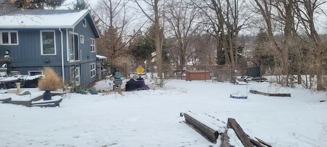 yard covered in snow featuring a garage and fence