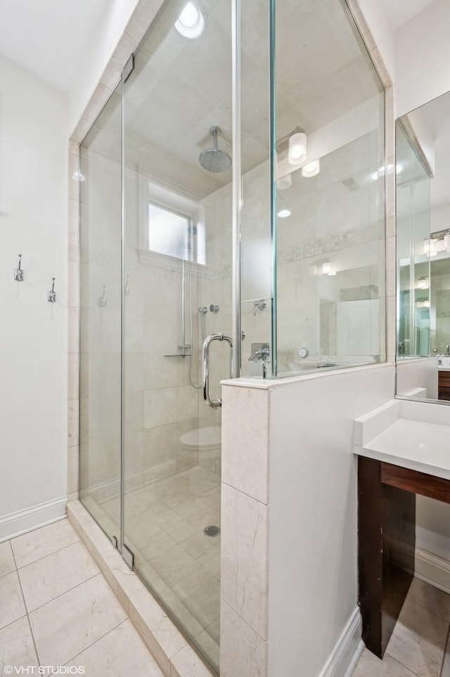 full bath featuring tile patterned floors, a shower stall, baseboards, and vanity