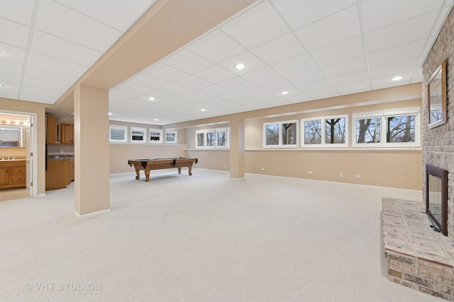 rec room featuring baseboards, recessed lighting, a fireplace, and light colored carpet