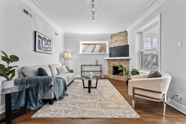 living area featuring a fireplace, baseboards, dark wood finished floors, and crown molding