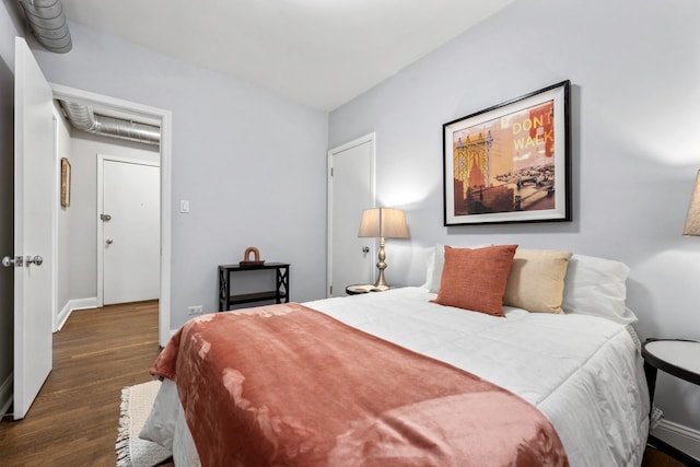 bedroom with baseboards and dark wood-type flooring