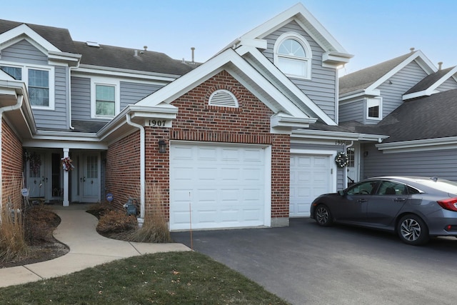 view of front of house featuring a garage, brick siding, and aphalt driveway