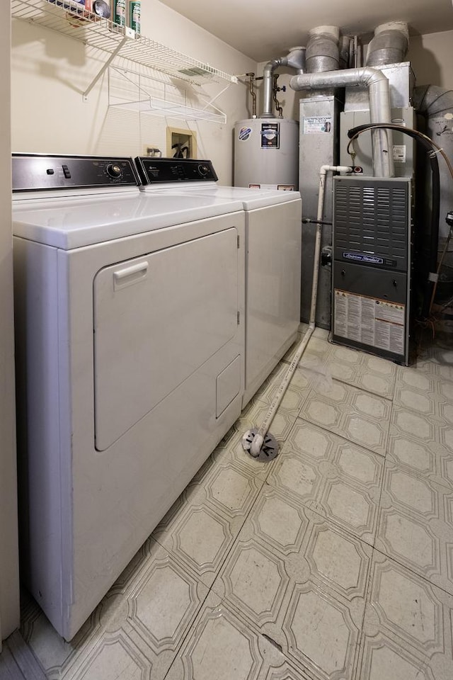 laundry area featuring laundry area, water heater, heating unit, light floors, and washing machine and clothes dryer