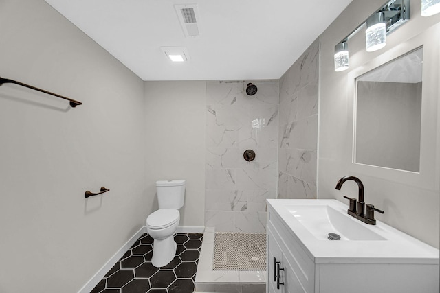 bathroom with baseboards, visible vents, tiled shower, toilet, and vanity