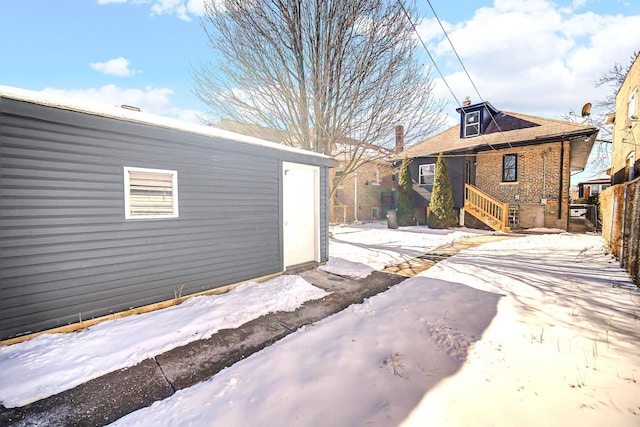 snow covered house with brick siding