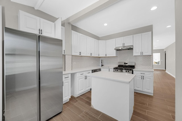 kitchen featuring white cabinetry, under cabinet range hood, wood tiled floor, and appliances with stainless steel finishes