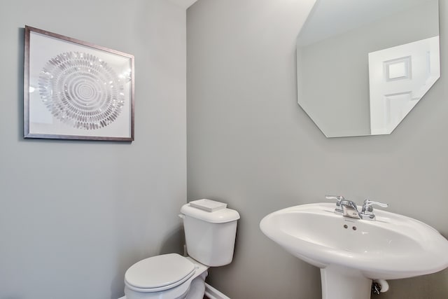 bathroom with baseboards, a sink, and toilet