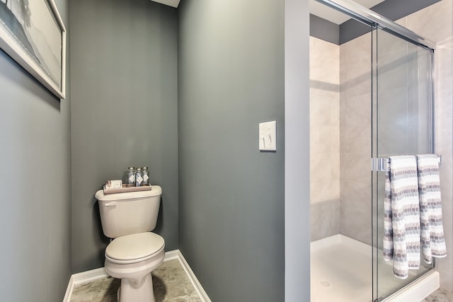 full bathroom featuring baseboards, a shower stall, and toilet