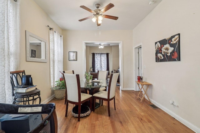 dining space featuring light wood-style flooring, visible vents, and baseboards