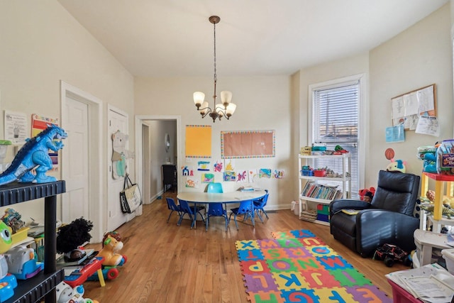 rec room with a chandelier, wood finished floors, and baseboards