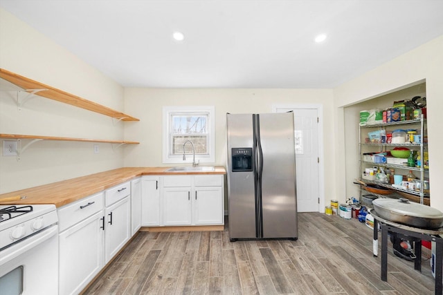 kitchen featuring light wood-style flooring, stainless steel refrigerator with ice dispenser, white gas stove, open shelves, and a sink