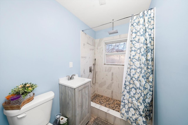 full bath featuring toilet, a tile shower, and a sink