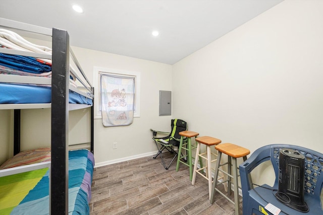 bedroom with recessed lighting, electric panel, baseboards, and wood finished floors