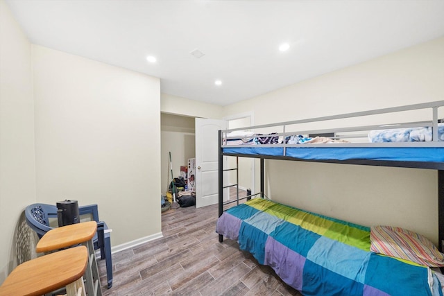 bedroom featuring baseboards, wood finished floors, and recessed lighting