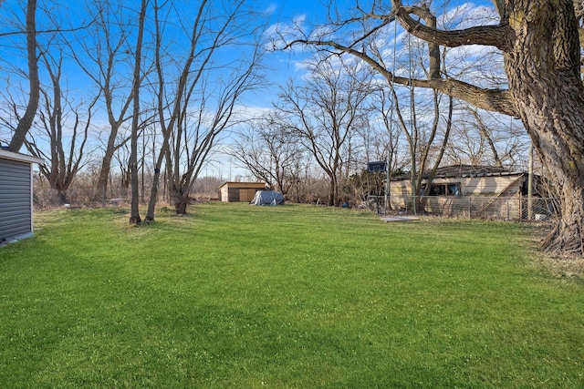 view of yard with a storage shed, fence, and an outdoor structure