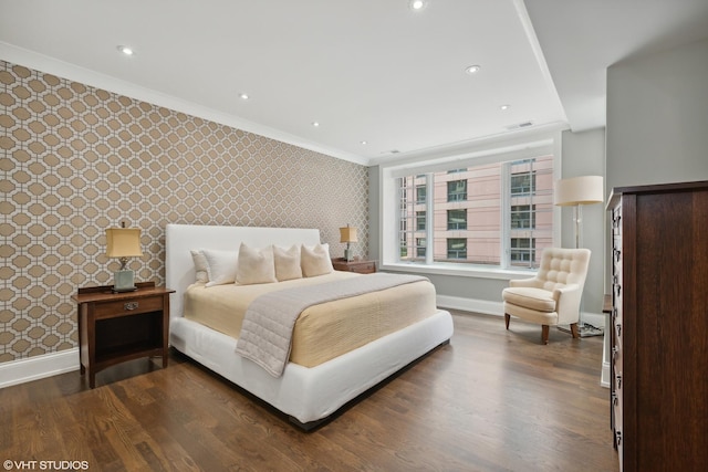 bedroom with dark wood-type flooring, ornamental molding, baseboards, and wallpapered walls