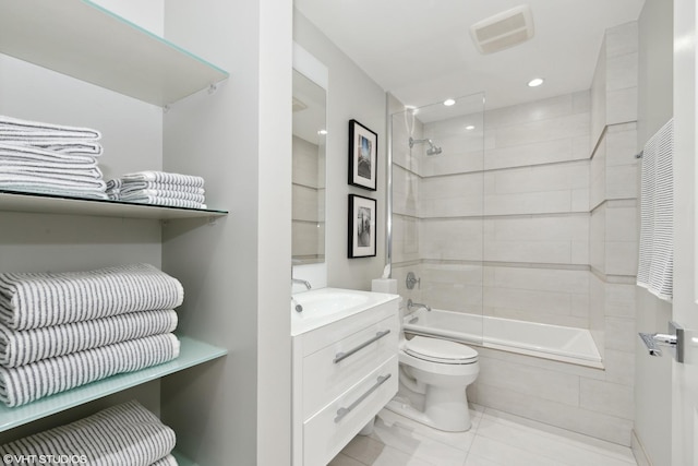 bathroom with visible vents, toilet, tiled shower / bath combo, vanity, and tile patterned floors