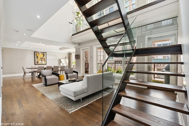 staircase featuring recessed lighting, wood finished floors, and baseboards