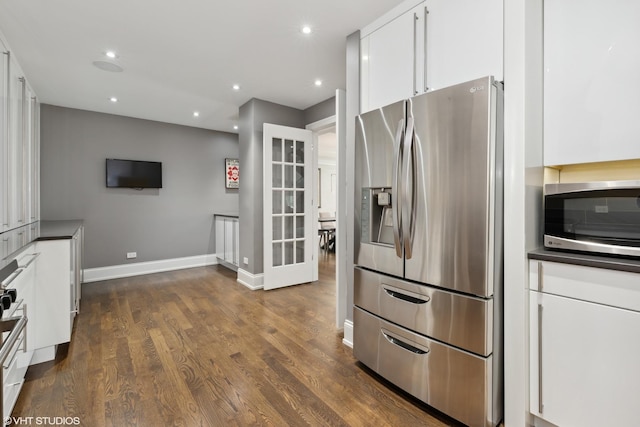 kitchen with recessed lighting, stainless steel appliances, white cabinets, dark wood-style floors, and dark countertops