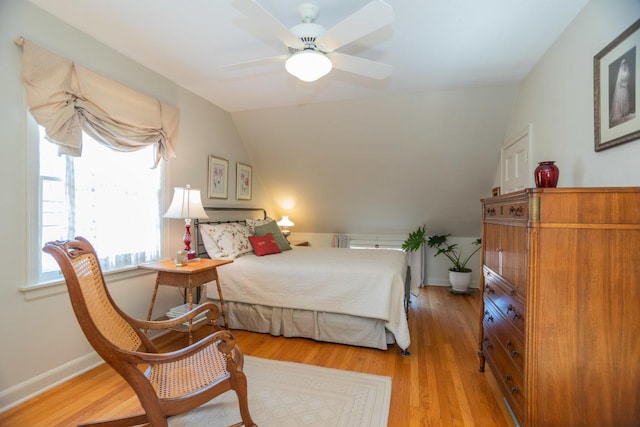 bedroom with ceiling fan, baseboards, lofted ceiling, and light wood-style floors