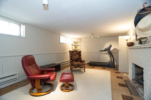 living area with a brick fireplace, a wealth of natural light, and wainscoting