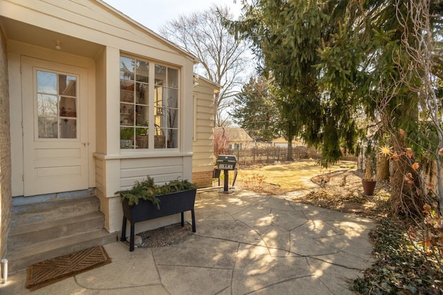 view of patio / terrace featuring a grill, entry steps, and fence