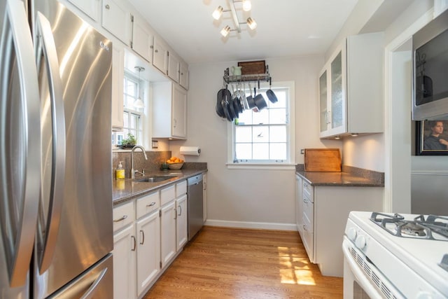 kitchen featuring a sink, a wealth of natural light, appliances with stainless steel finishes, and white cabinets