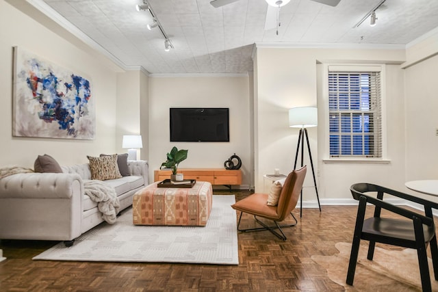 living room featuring ceiling fan, track lighting, baseboards, and crown molding