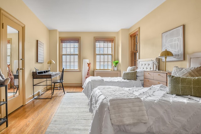 bedroom with baseboards and light wood finished floors