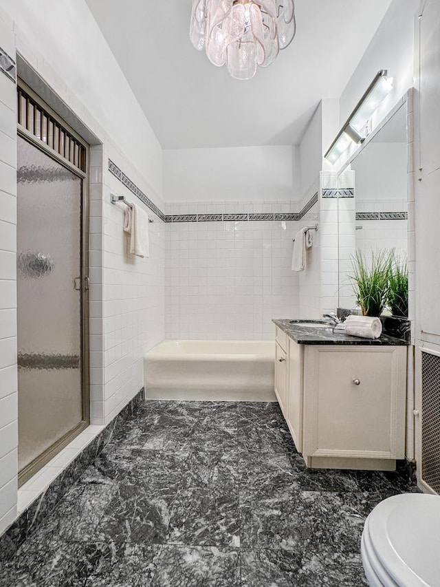 bathroom featuring tile walls, toilet, a shower stall, and vanity