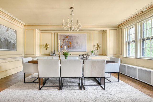 dining space featuring a notable chandelier, a decorative wall, wood finished floors, radiator heating unit, and crown molding