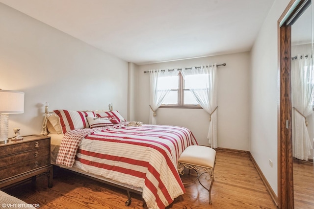 bedroom featuring baseboards and wood finished floors