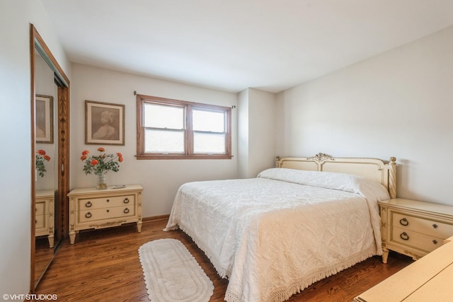 bedroom featuring dark wood-style floors and baseboards