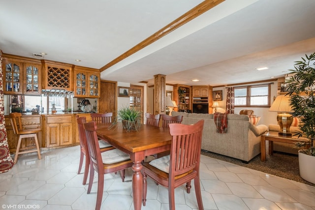 dining space with recessed lighting, bar, and decorative columns