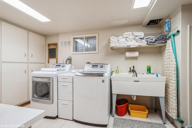 laundry area with cabinet space, visible vents, light tile patterned flooring, a sink, and independent washer and dryer